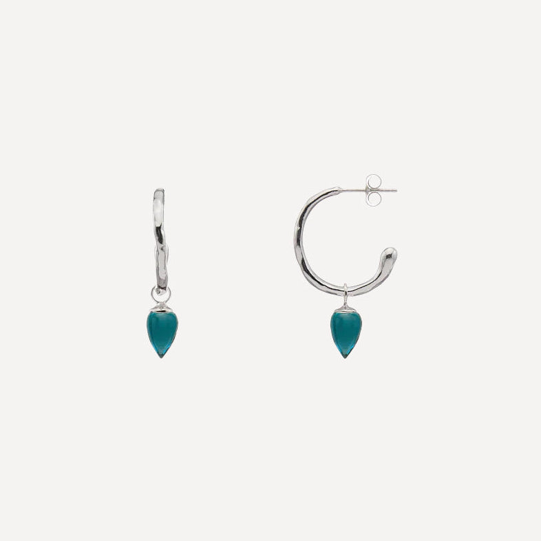 A pair of silver hoop earrings with a small silver hanger and a dangling teardrop-shaped turquoise stone, shown against a light gray background.